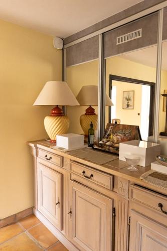 Cette chambre dispose d'un comptoir avec une lampe et un miroir. dans l'établissement Chambres d'hôtes Château de Jonquières, à Narbonne