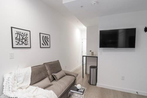 a living room with a couch and a flat screen tv at Unit 2 Cozy One bed in the heart of Dc in Washington, D.C.