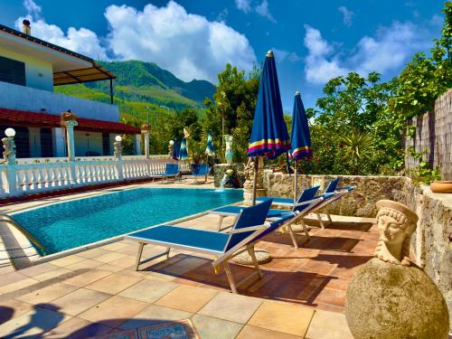 a pool with lounge chairs and umbrellas on a patio at Hotel Villa Fiorentina in Ischia