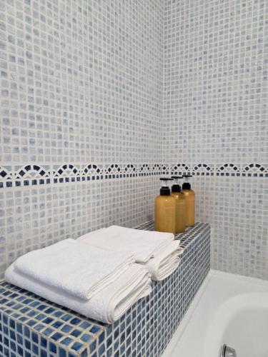 a bathroom with white towels and a bath tub at La Casetta al Lido in Alghero