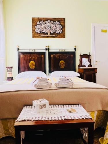 a bedroom with a bed with a table with towels on it at B&B DOÑA FLOR in Parabita