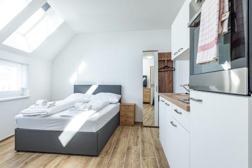 a small bedroom with a bed and a refrigerator at GREEN & CONNECTED by JR City Apartments in Vienna