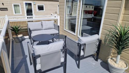 een patio met 2 stoelen en een tafel op een veranda bij Coastal Retreat Lodge in Morecambe