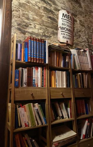 two wooden book shelves filled with books in a room at Aldea A Paínza in Arzúa