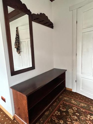 a bathroom with a mirror and a wooden dresser at Leśne PoBudki in Białowieża