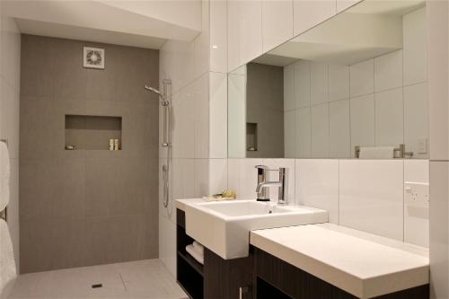 a white bathroom with a sink and a shower at Kokomo Retreat in Russell