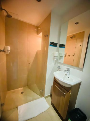 a bathroom with a shower and a sink at Hotel Metropolis Plaza Cali in Cali