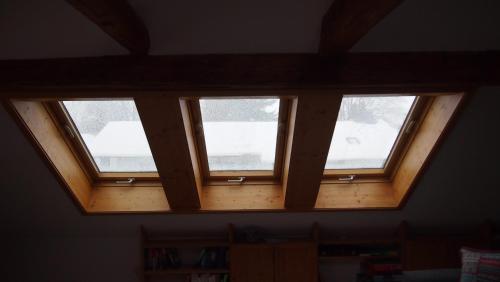 three windows in a room with a wooden ceiling at Im Juchhe in Peiting