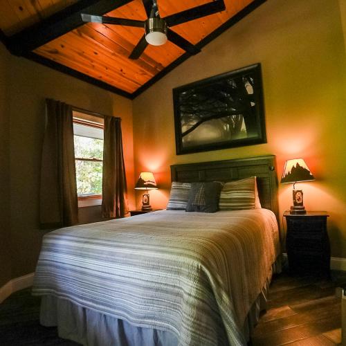 a bedroom with a bed and a ceiling fan at Treetop - by The Chalets in Logan