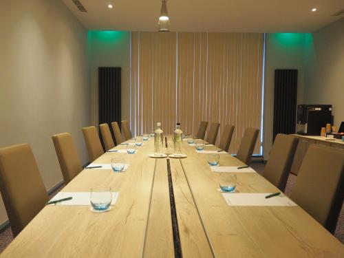 a long wooden table in a conference room with chairs at Holiday Inn Telford Ironbridge by IHG in Telford