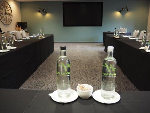 two bottles of water sitting on tables in a room at Holiday Inn Telford Ironbridge by IHG in Telford