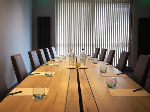 a long table with wine glasses and bottles on it at Holiday Inn Telford Ironbridge by IHG in Telford