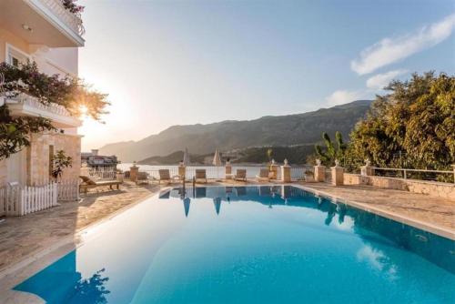 a large blue swimming pool next to a building at Club Çapa Hotel in Kas