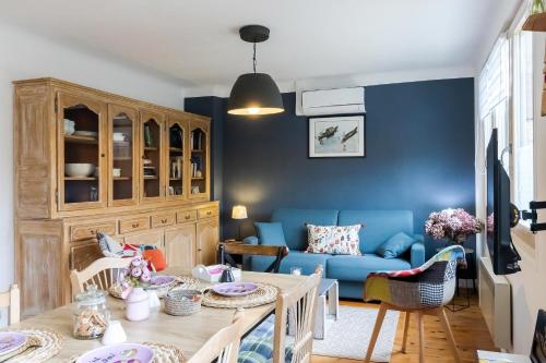 a living room with a blue couch and a table at Maloan, gite avec piscine in Saint-Julien-de-Lampon
