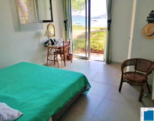 une chambre avec un lit, une table et des chaises dans l'établissement Villa ACONIT - Les pieds dans l'eau, à Lecci