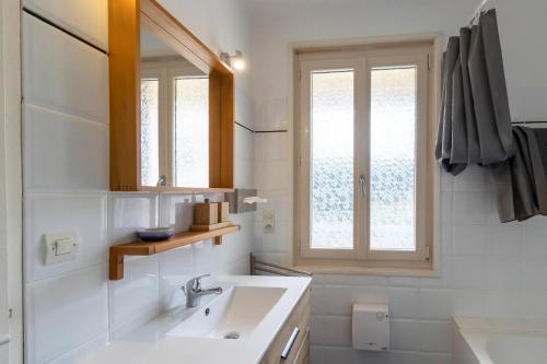 a white bathroom with a sink and a window at Maloan, gite avec piscine in Saint-Julien-de-Lampon