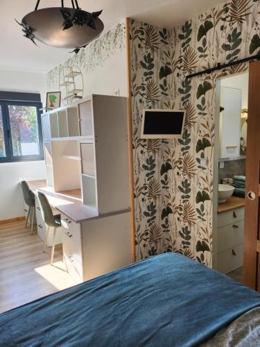 une chambre avec un lit et un bureau et une cuisine dans l'établissement Appartement à la campagne au calme, à La Celle-sous-Gouzon