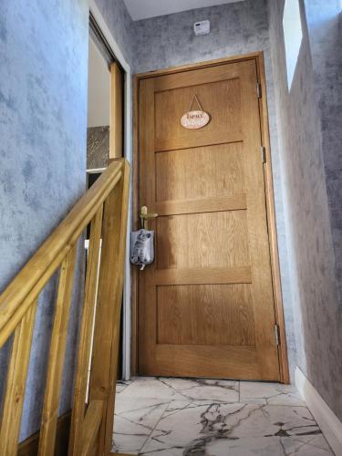 une porte en bois dans un couloir avec un escalier dans l'établissement Appartement à la campagne au calme, à La Celle-sous-Gouzon