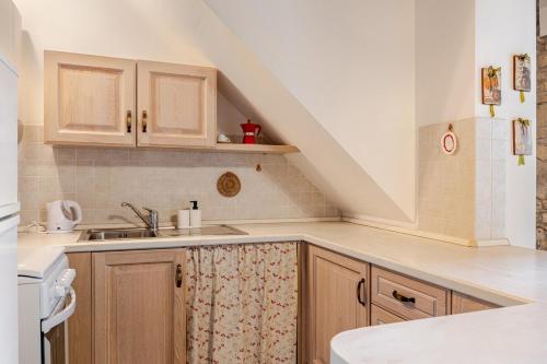 a kitchen with wooden cabinets and a sink at Romantica Residenza - Borgo Castello di Serravalle in Castello di Serravalle