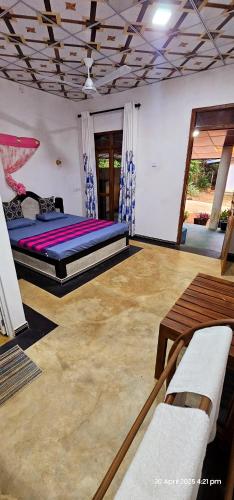 a bedroom with a bed and a table and chairs at Dilanya Homestay in Habarana