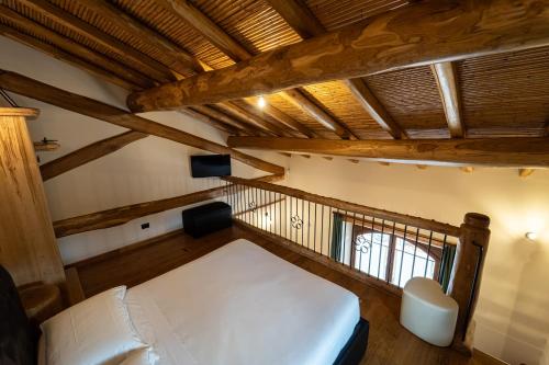 a bedroom with a white bed and a wooden ceiling at Etna Quota Mille Boutique Hotel, Typical Sicilian Food & Wine in Randazzo