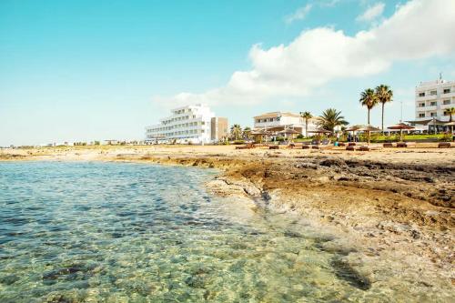 a view of the beach with buildings in the background at Piere - Anne Beach Hotel in Ayia Napa