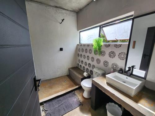 a bathroom with a white toilet and a sink at Hartbeest Bush Lodge 30 in Hartbeespoort