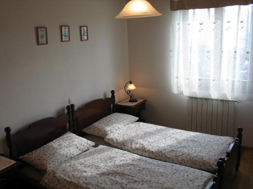 two twin beds in a bedroom with a window at Tourist Farm Žvanč in Kobarid
