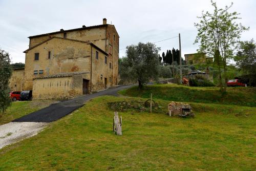 an old building on a hill next to a road at Casa Zeno in Volterra