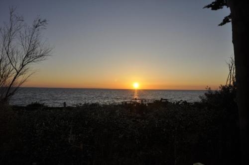 a sunset over the ocean with the sun setting at Panorama Vue Mer in Quiberon
