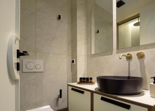 a bathroom with a sink and a mirror at Allegro Suites in Rethymno Town
