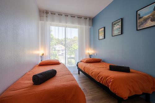 deux lits dans une chambre avec une fenêtre dans l'établissement Ocean 90 face mer, à La Baule