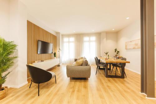 a living room with a table and a dining room at Bravissimo Ferreries Velles, with 2 bedrooms in Girona