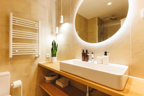 a bathroom with a white sink and a mirror at Bravissimo Ferreries Velles, with 2 bedrooms in Girona