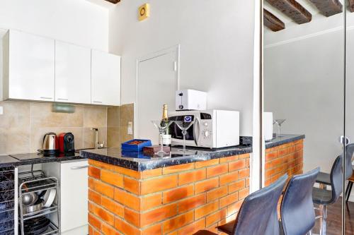 une cuisine avec des placards blancs et un comptoir avec un four micro-ondes dans l'établissement 5016 Suite Saint-Jacques - Cosy studio Paris 5th, à Paris