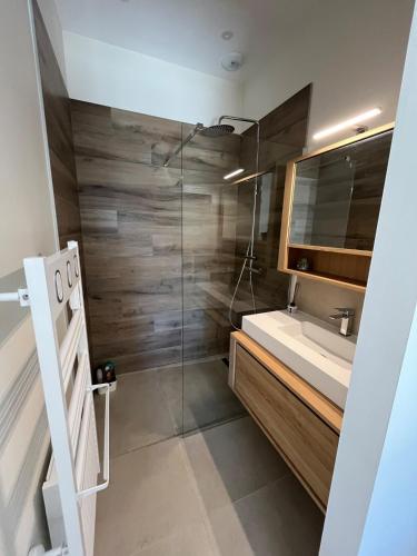 une salle de bain avec un lavabo et une douche en verre dans l'établissement Maison Contemporaine Neuve, à Éguilles
