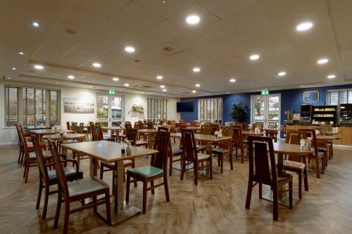 a dining room with wooden tables and chairs at Holiday Inn Express Poole by IHG in Poole
