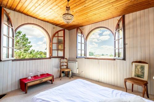 une chambre avec un lit dans une pièce avec des fenêtres dans l'établissement Maison avec jardin proche mer, à Pornic