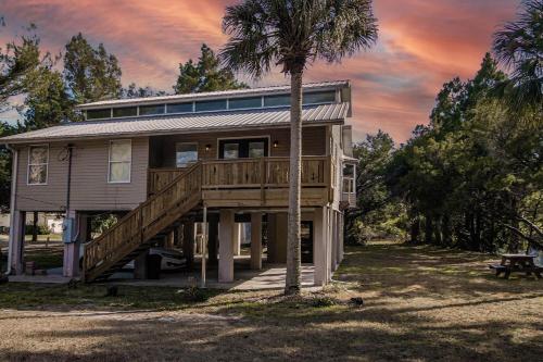 a house with a large deck and a palm tree at River Rats Rest in Homosassa