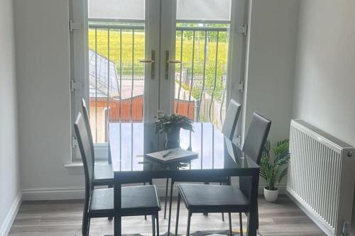 a dining room with a glass table and chairs at Lanarkshire Apartment- Views- Sleeps 4- Balcony in Larkhall