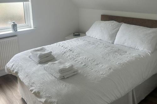 a white bed with towels on it in a bedroom at Lanarkshire Apartment- Views- Sleeps 4- Balcony in Larkhall