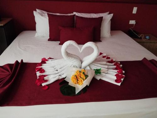 two swans made out of towels on a bed at Bajo la luna hotel in Medellín
