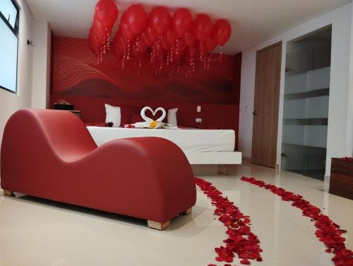 a bedroom with a heart shaped bed and a red chair at Bajo la luna hotel in Medellín