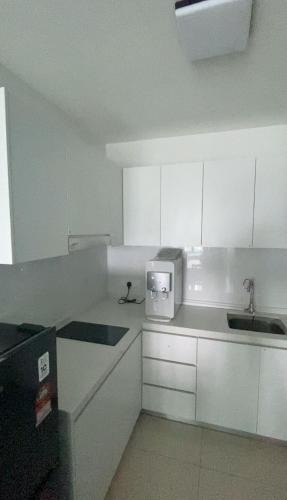 a white kitchen with a sink and a microwave at Tulips Cozy Homestay For You in Shah Alam