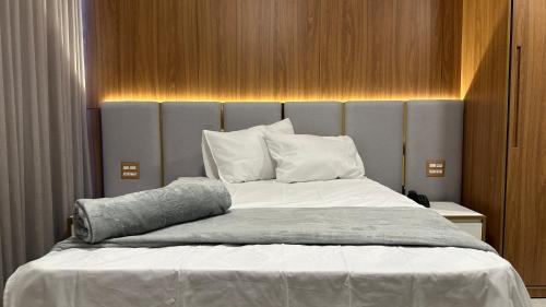 a bedroom with a large bed with white sheets and pillows at Hotel Cachoeira in Cajazeiras