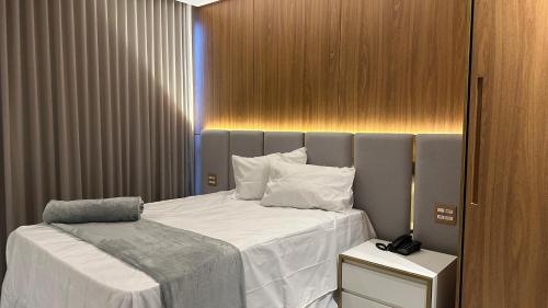 a bedroom with a bed with white sheets and pillows at Hotel Cachoeira in Cajazeiras