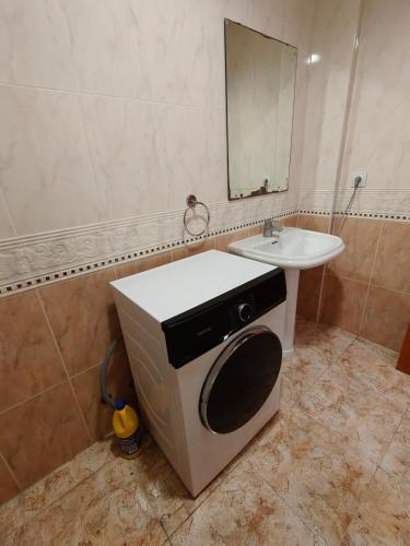 a bathroom with a sink and a washing machine at Seawolf Apartment, Lloret de Mar in Lloret de Mar