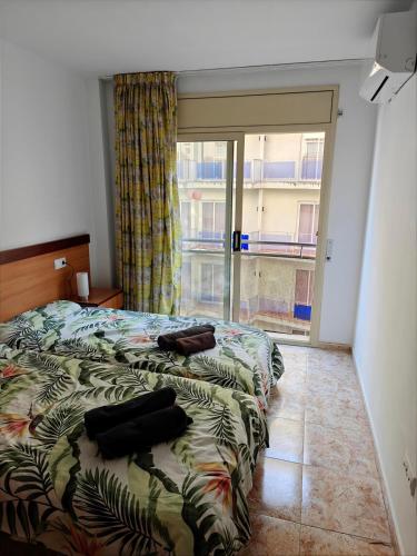 a bedroom with two beds and a large window at Seawolf Apartment, Lloret de Mar in Lloret de Mar