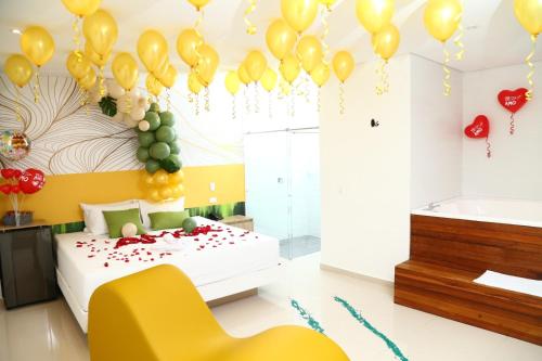 a bedroom with balloons and a bed and a tub at Bajo la luna hotel in Medellín