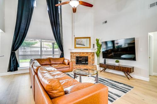 a living room with a leather couch and a fireplace at 2 Mi to Old Town Spacious Burleson Vacation Home in Burleson